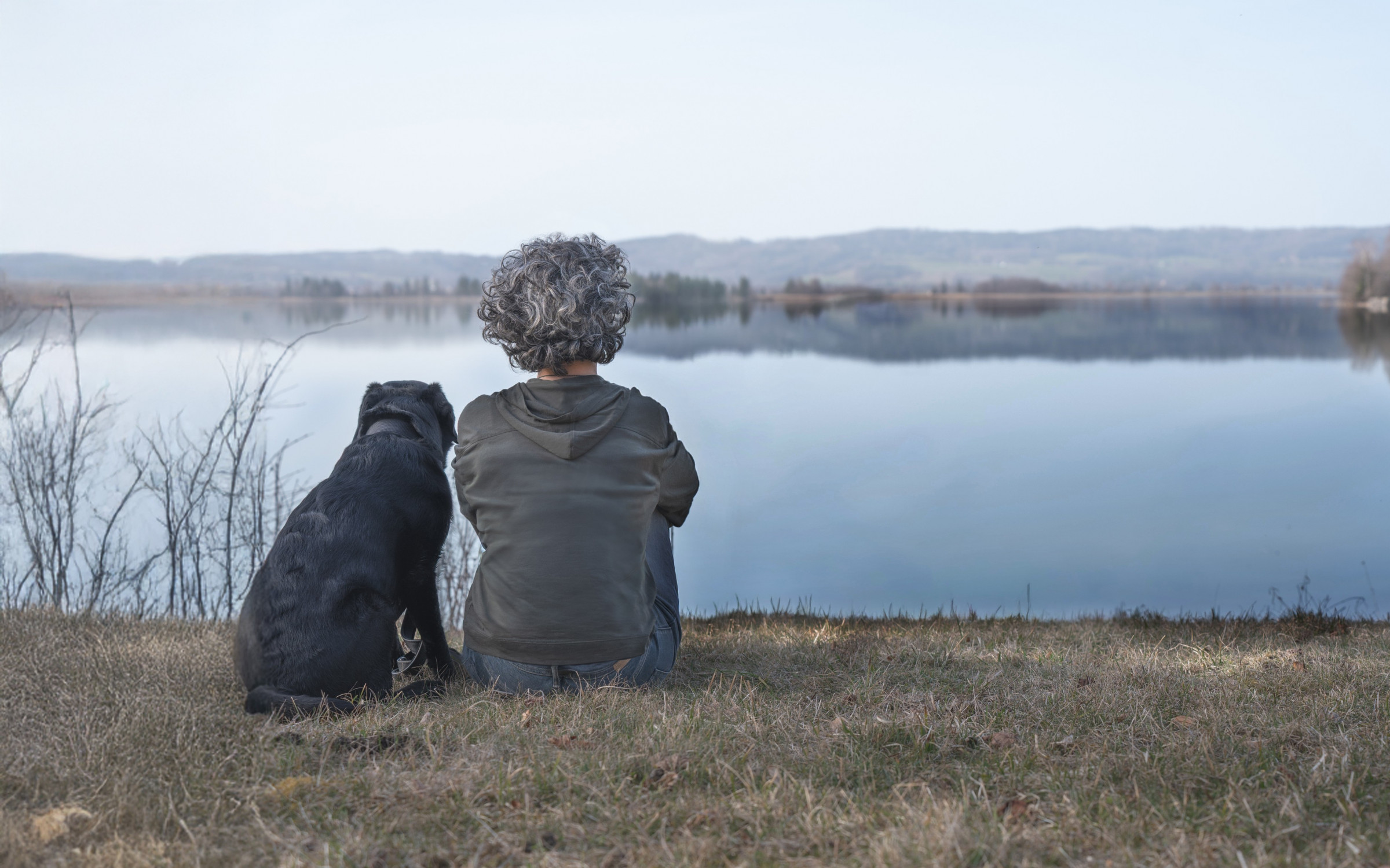 Eva-Maria Pitman mit Hund am See, MittenKraft Mensch-Hund-Begleitung, Beziehung gestalten, ruhige Präsenz, Verbindung Mensch und Hund